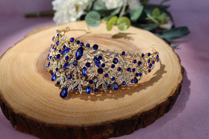 a blue and gold tiara sitting on a piece of wood