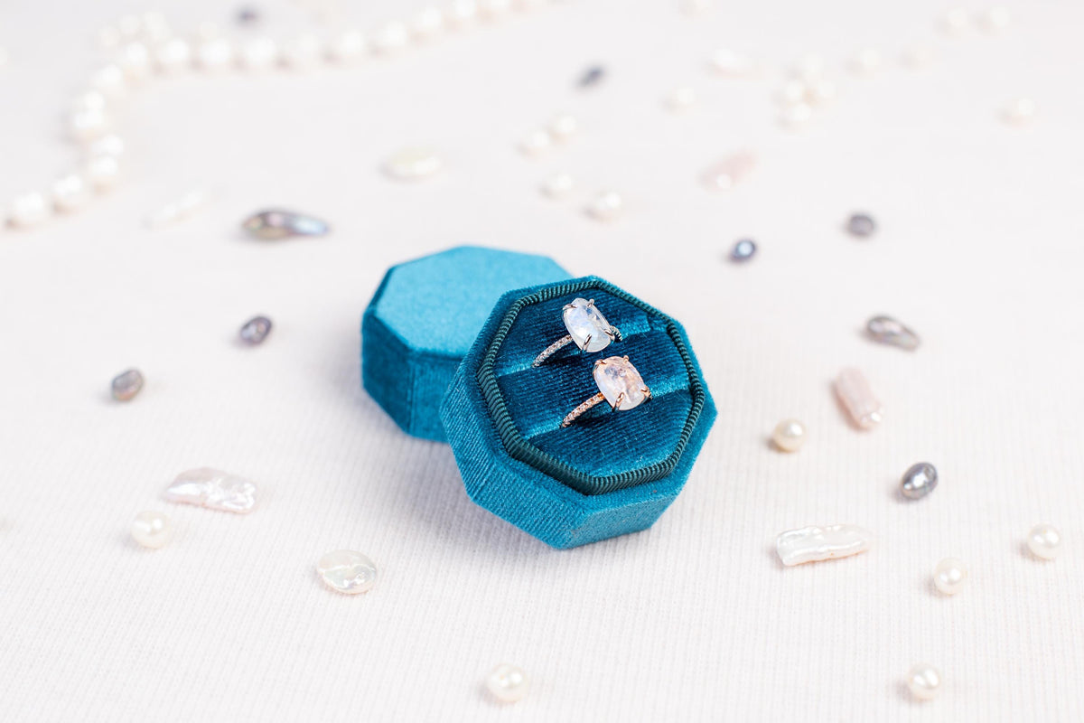 a couple of rings sitting inside of a blue ring box