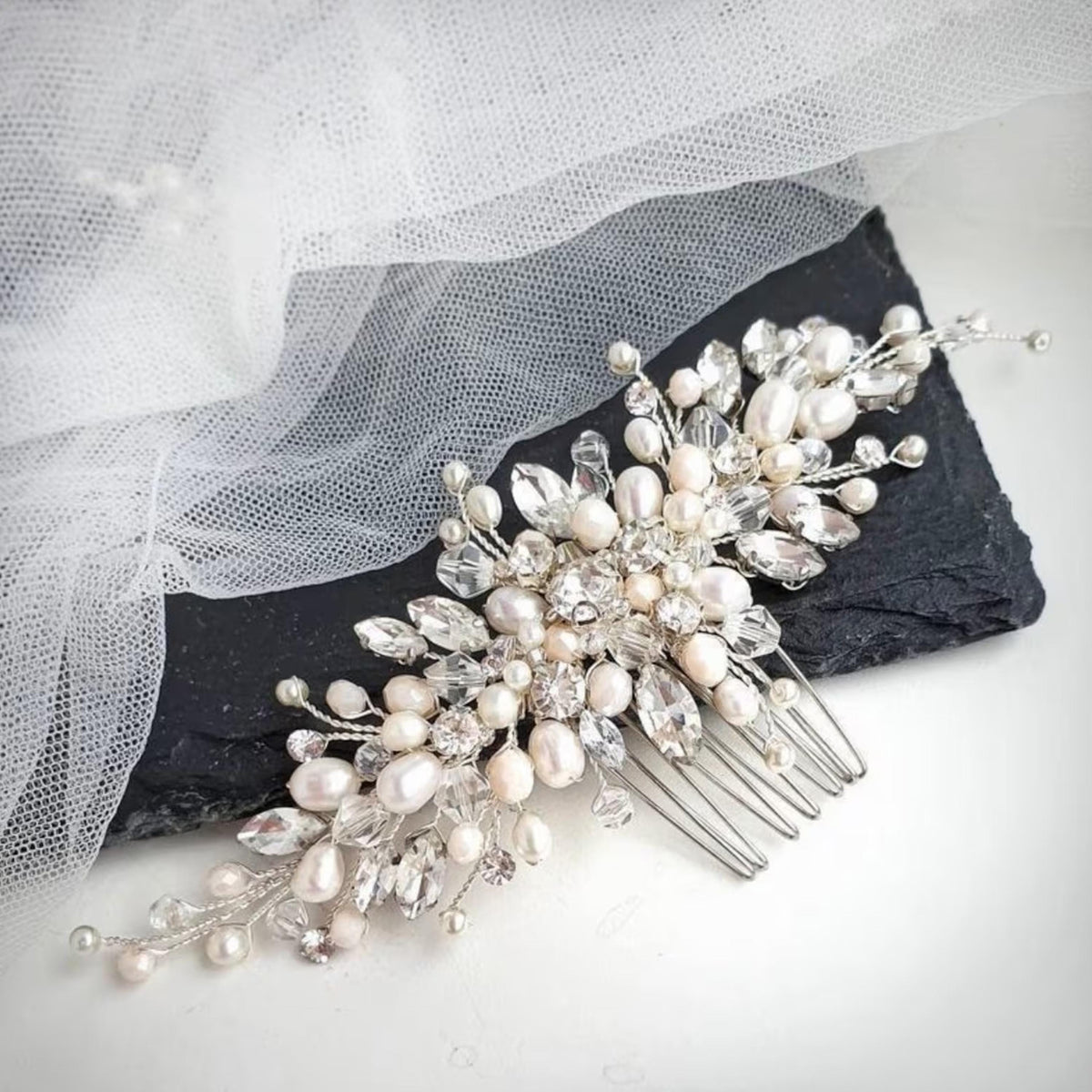 A decorative hair accessory with a floral design and numerous small pearls and crystals.