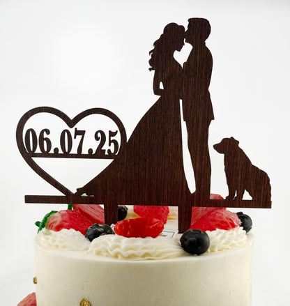 a wedding cake topper with a couple and a dog