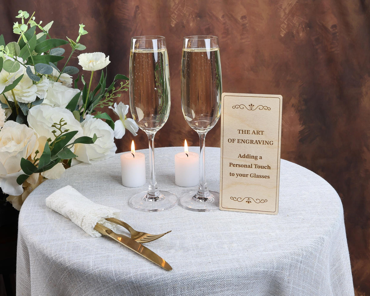 a table topped with two glasses of wine and a sign
