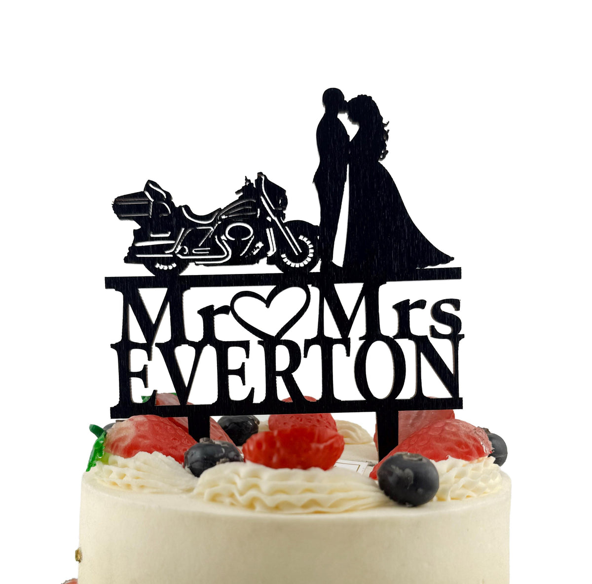 A black silhouette of a bride and groom on top of a cake, with the words "Mr. Everton" written below them.