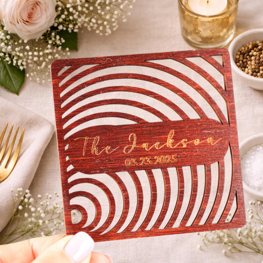 a wooden card with a decorative cutout design, placed on a table with various items such as a candle, a bowl, and some flowers.