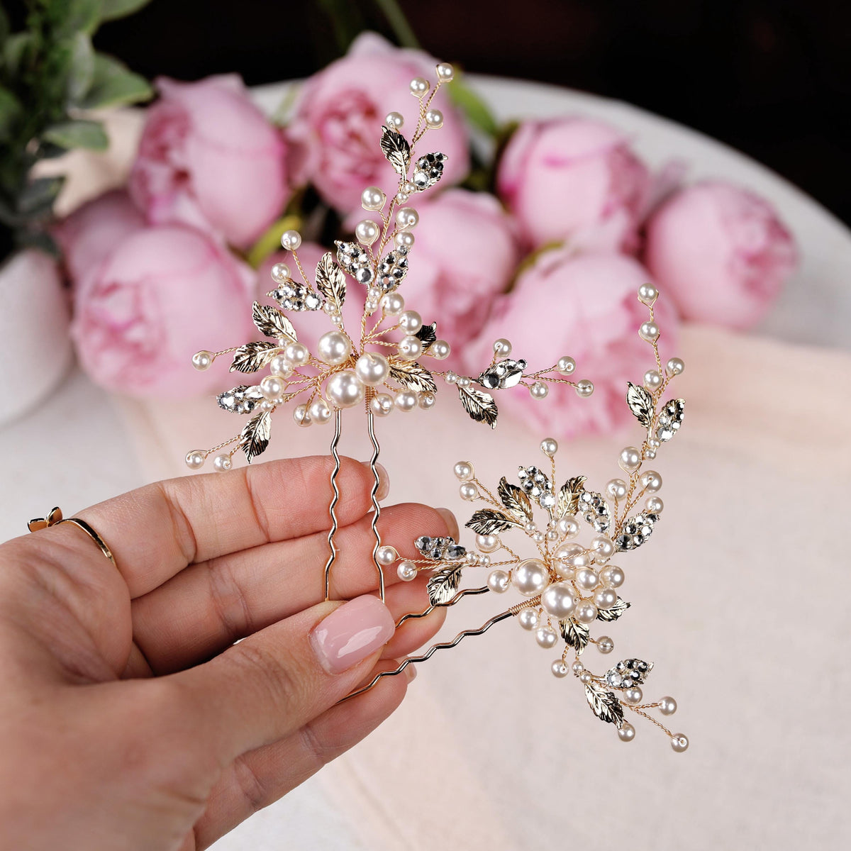 a hand holding a crystal and pearl snowflake
