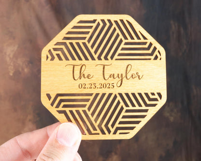 a person holding up a wooden coaster that says the taylor