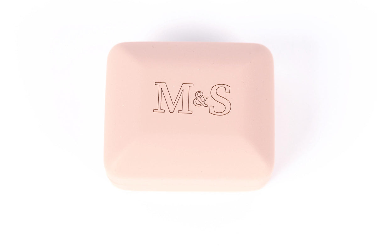 A pink square box with the letters 'M&S' printed on it.