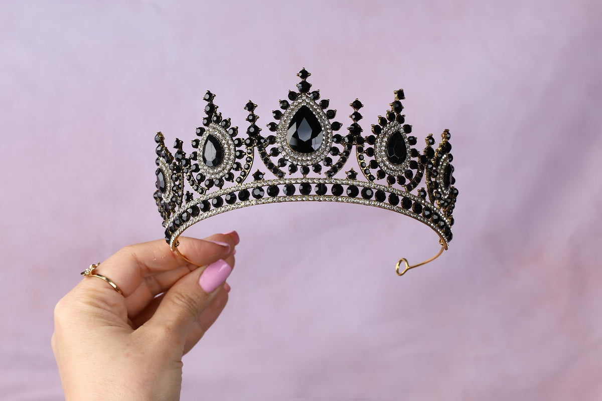 a woman is holding a tiara in her hand
