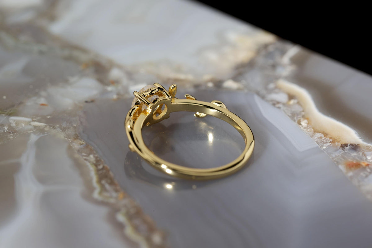 a close up of a gold ring on a marble surface