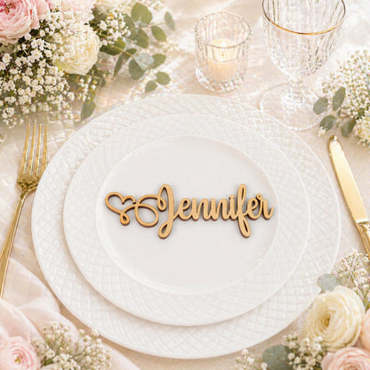 a beautifully set table with a white plate, a candle, and a floral arrangement. The nameplate on the plate says "Jennifer".