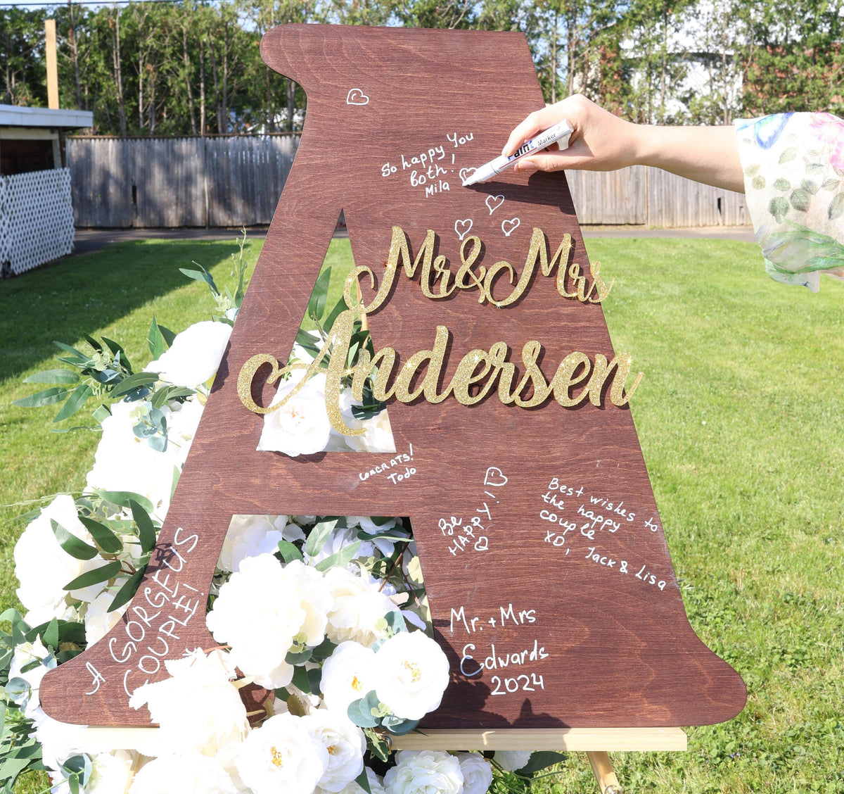 a wooden sign with writing on it in the grass