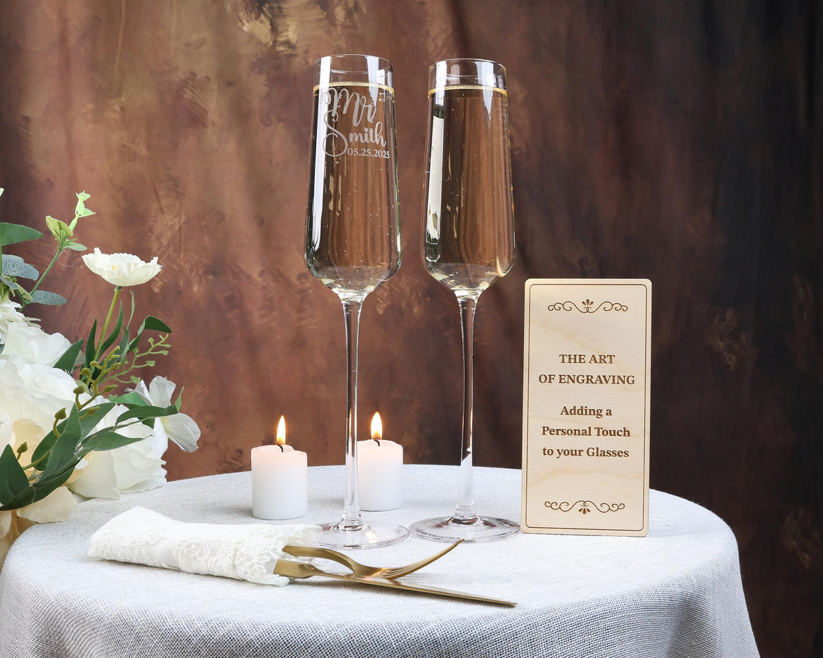two glasses of champagne sitting on a table with a sign
