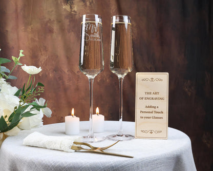 two glasses of champagne sitting on a table with a sign