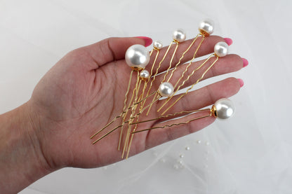 a person's hand holding a bunch of hair pins