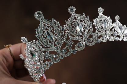 A close-up view of a sparkling silver tiara with intricate designs and sparkling gemstones.