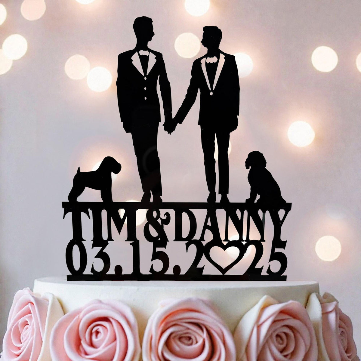 A silhouette of two men in suits holding hands, with a dog between them, on top of a cake. The text below the silhouette reads "Tim & Danny 03.15.25".