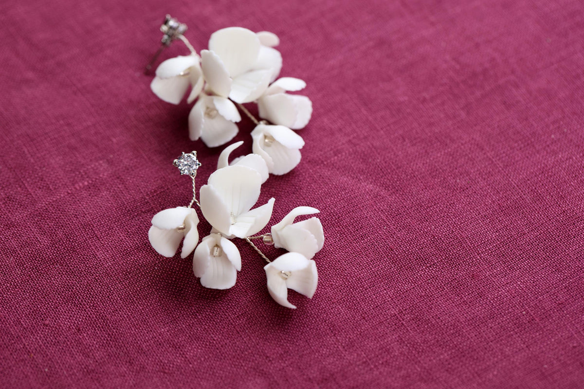 a pair of white flowers sitting on top of a purple cloth