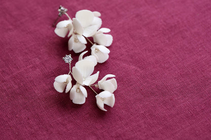 a pair of white flowers sitting on top of a purple cloth