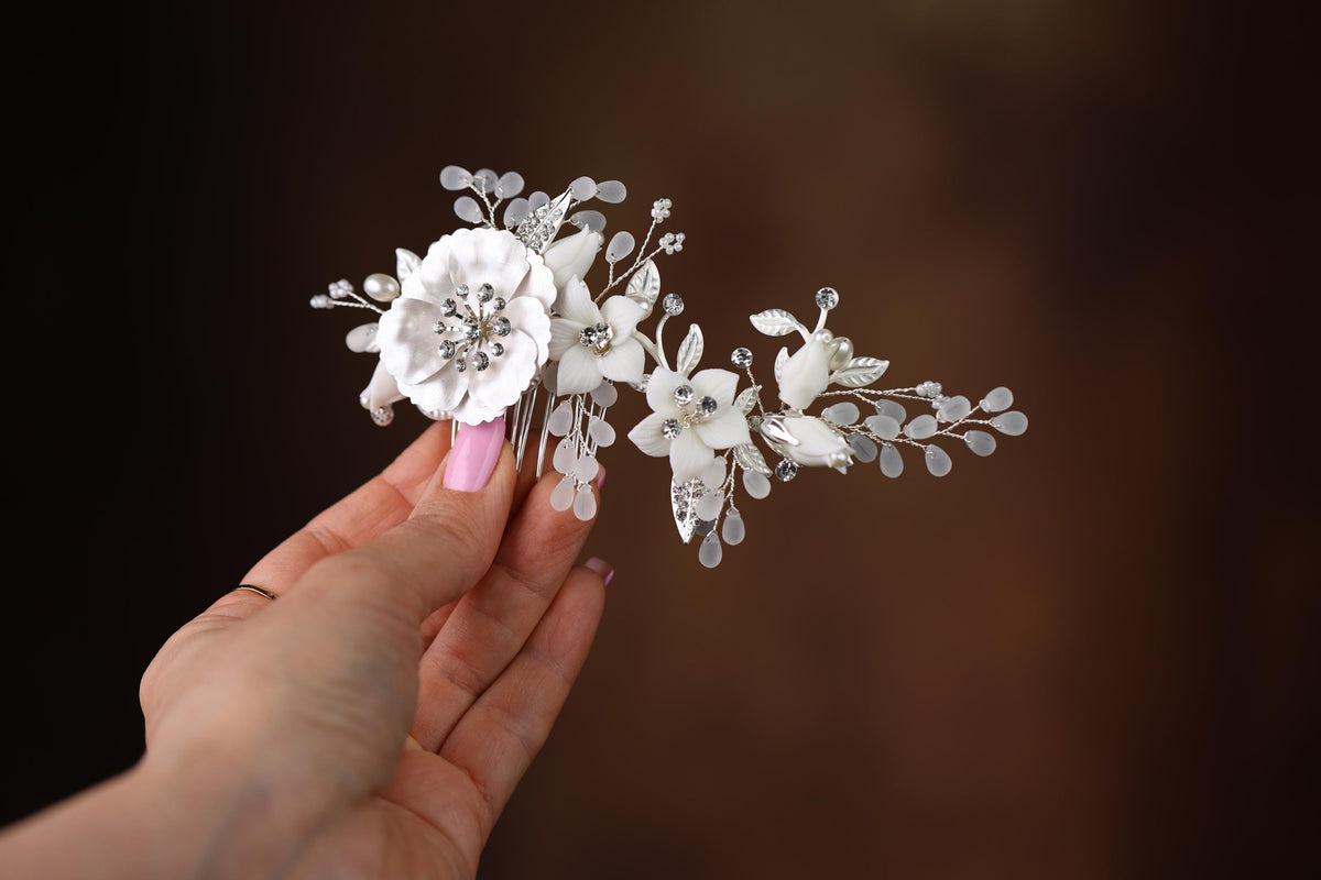 a hand holding a white flower and a hair comb