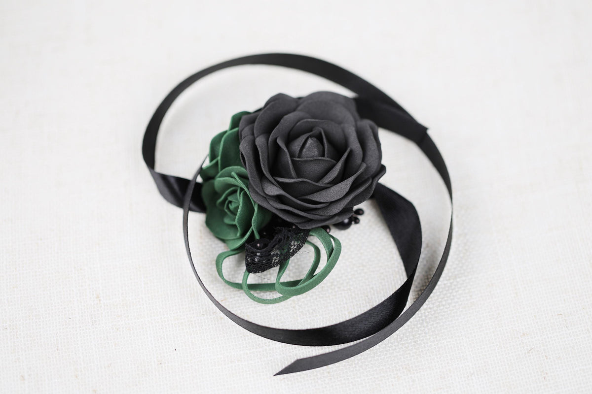 a black rose on a black ribbon on a white surface