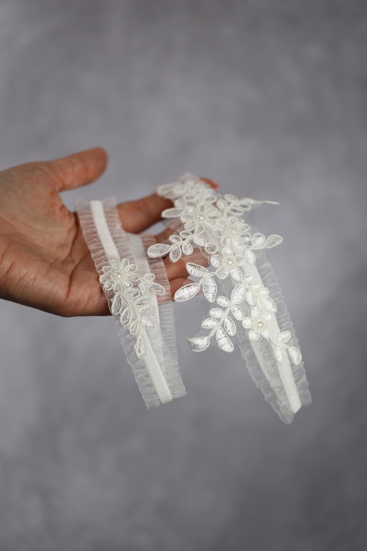 a hand holding a piece of white lace