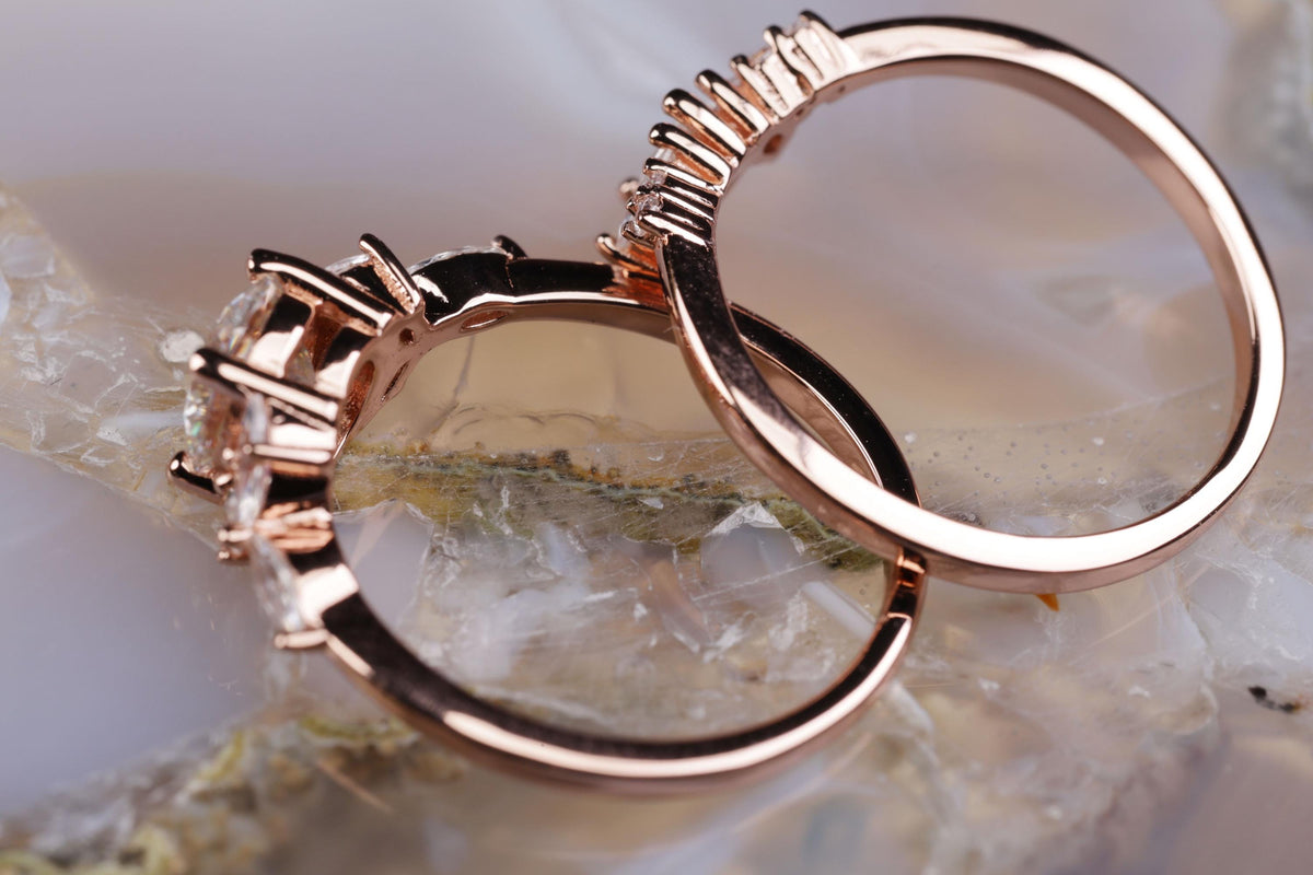 a couple of wedding rings sitting on top of a rock
