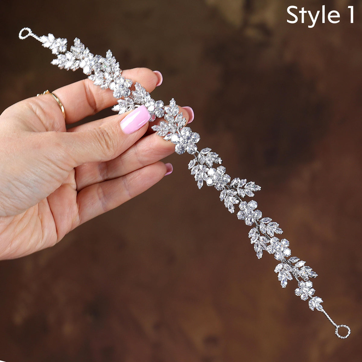 a woman's hand holding a tiara in her left hand
