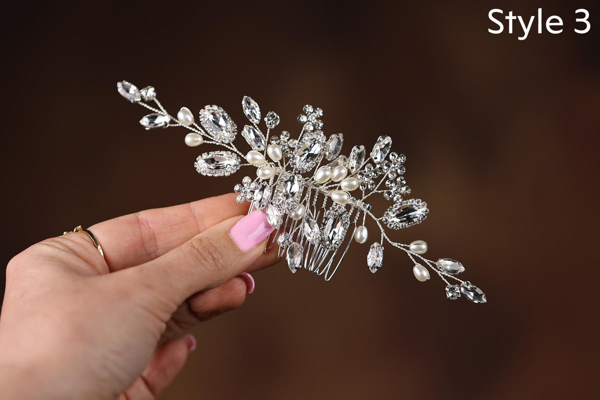 a hand holding a crystal and pearl hair comb
