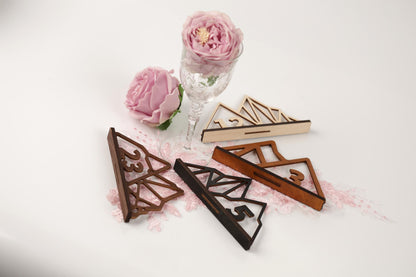 a pink rose, a glass vase, and several wooden or metal shapes with numbers on a white background.