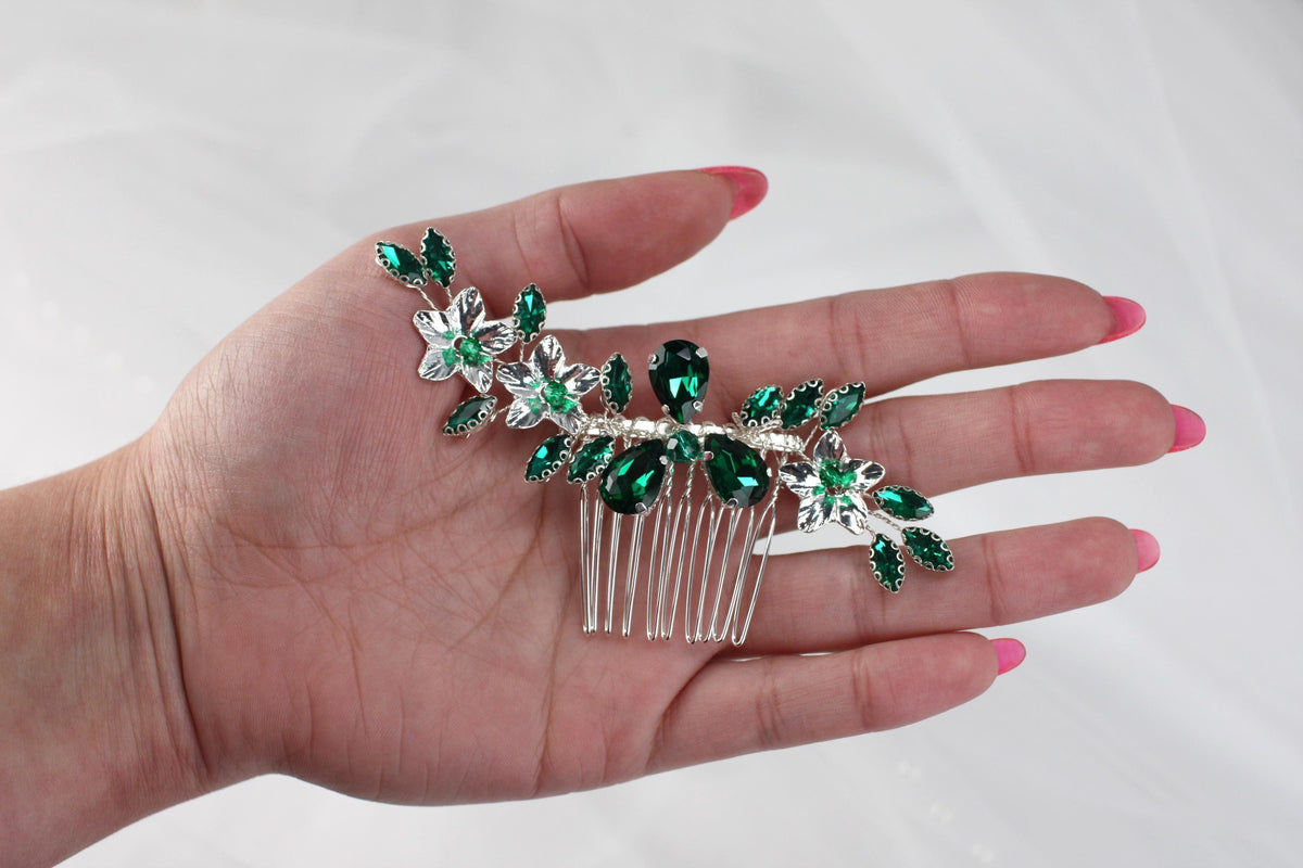 a woman's hand holding a green and white hair comb
