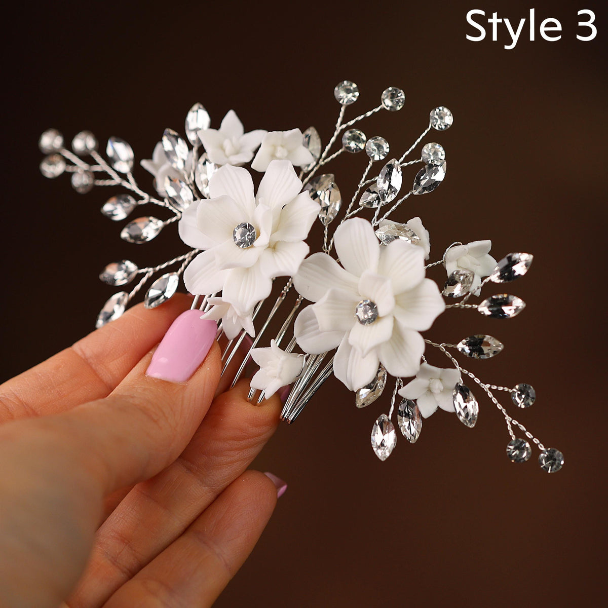 a woman's hand holding a hair comb with flowers on it
