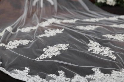 a wedding veil with white flowers on it