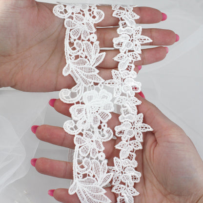 a woman's hand holding a piece of white lace