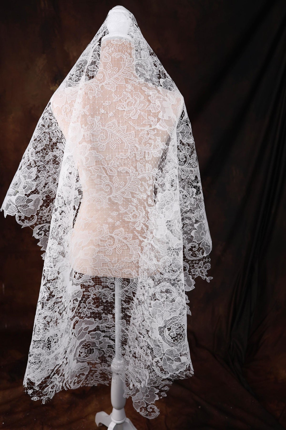 a wedding veil on a mannequin on a black background