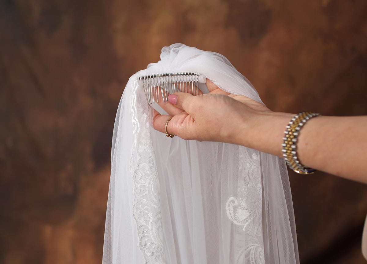 a person is holding a comb over a wedding dress