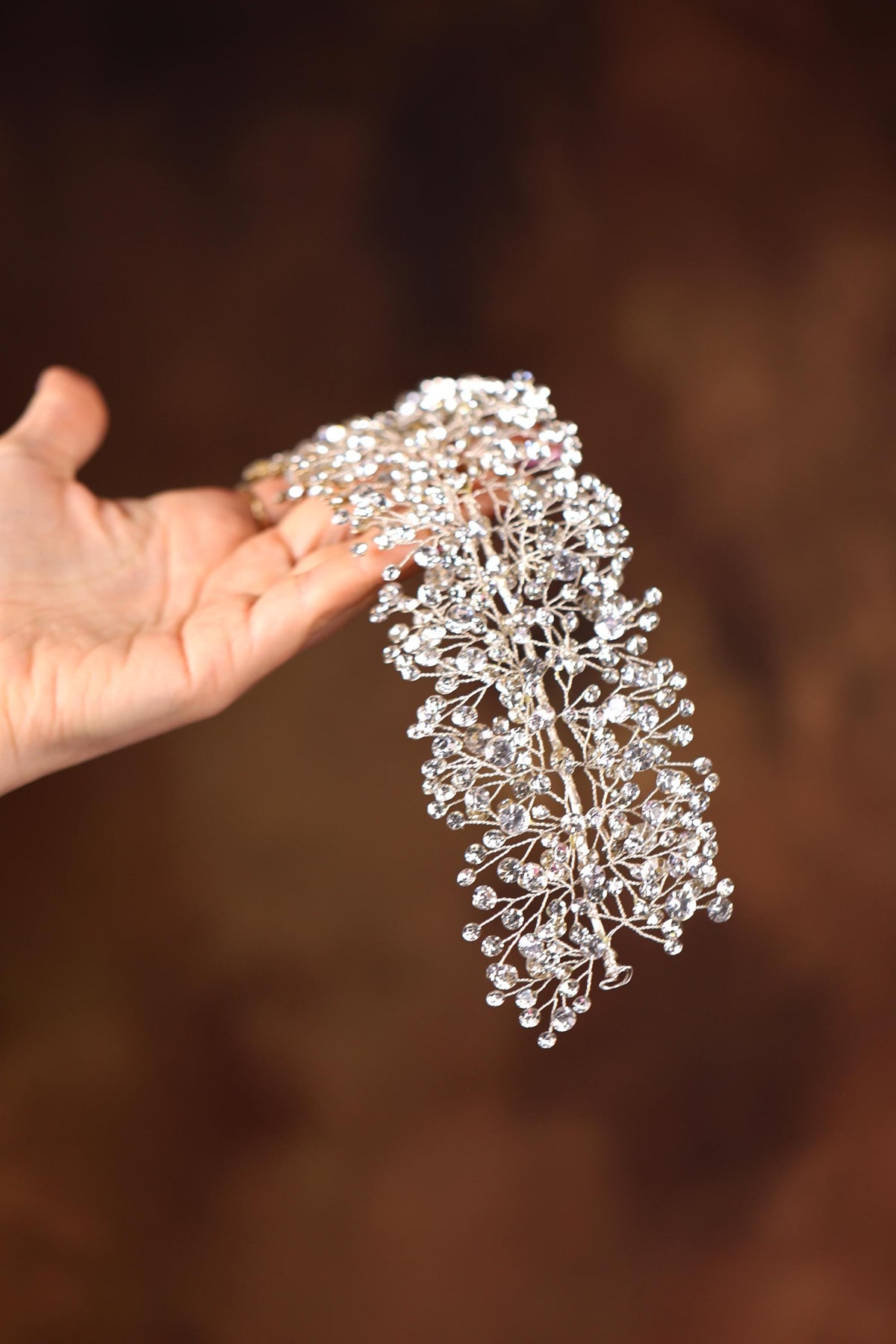 a person holding a piece of jewelry in their hand
