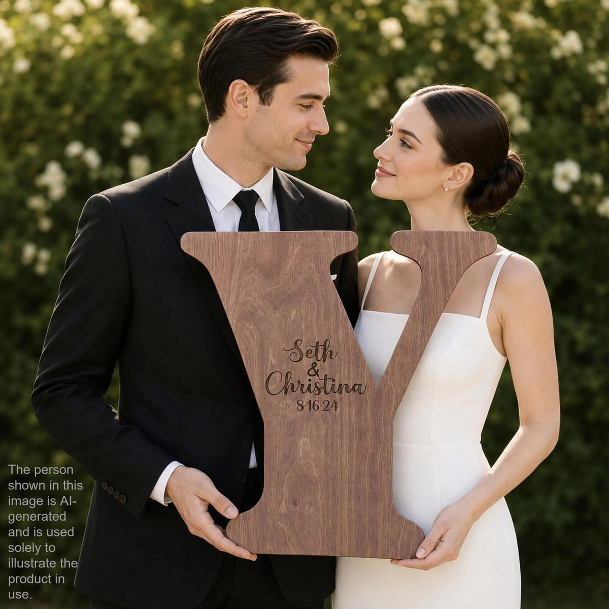 A man and a woman are holding a large wooden sign with the text "Seth & Christina 5/16/24" on it.