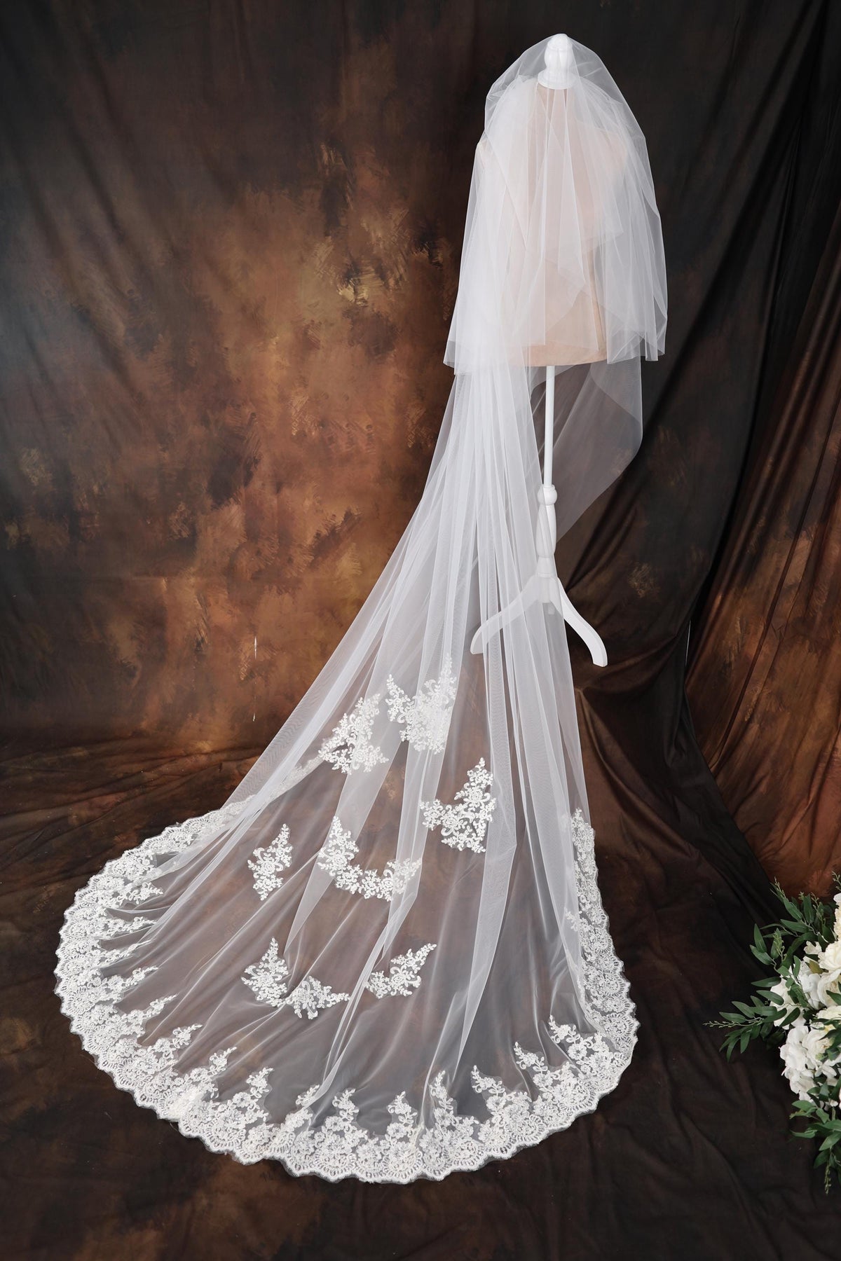 a wedding veil with a lace edge on a mannequin