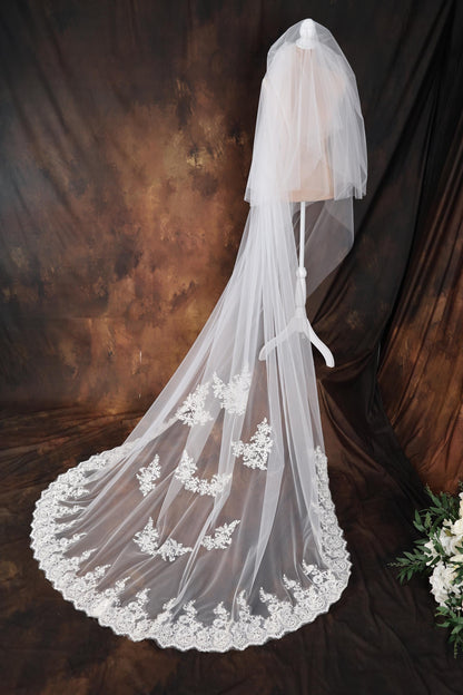 a wedding veil with a lace edge on a mannequin
