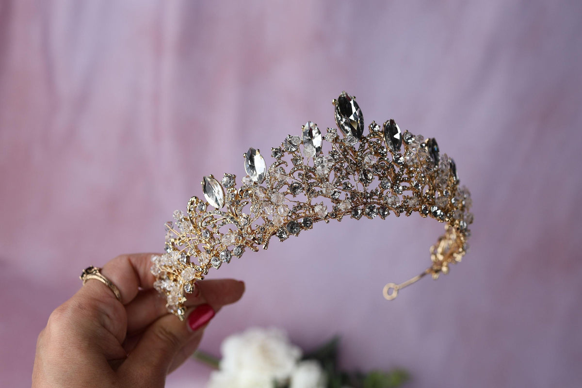 a woman is holding a tiara in her hand