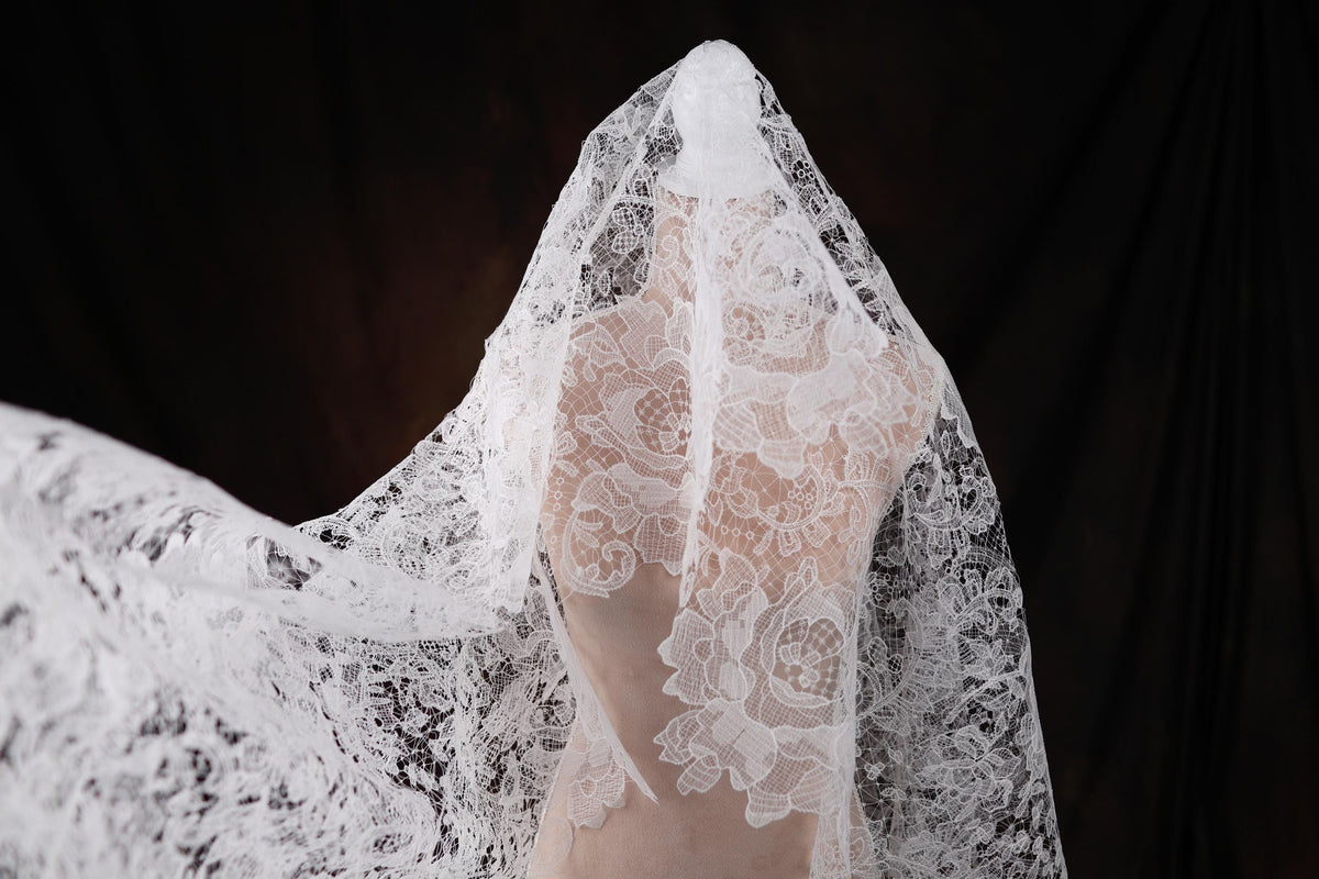 a woman wearing a white veil with flowers on it