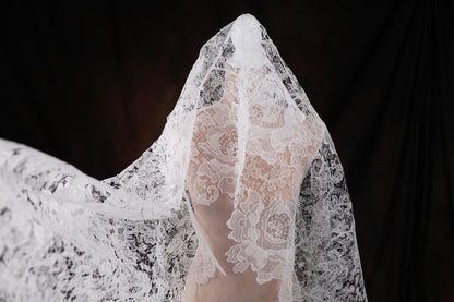 a woman wearing a white veil with flowers on it