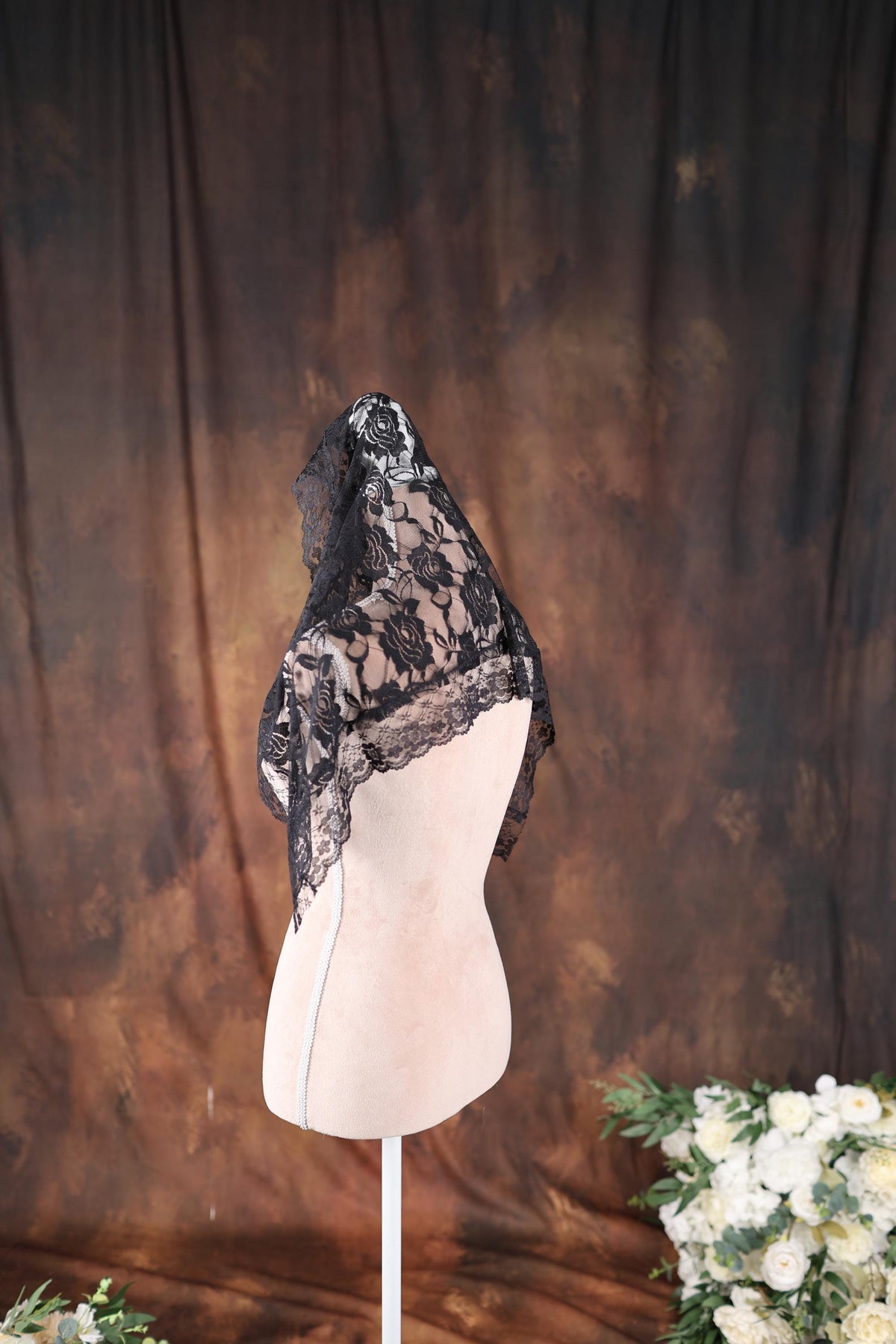 a white mannequin with a black scarf on top of it