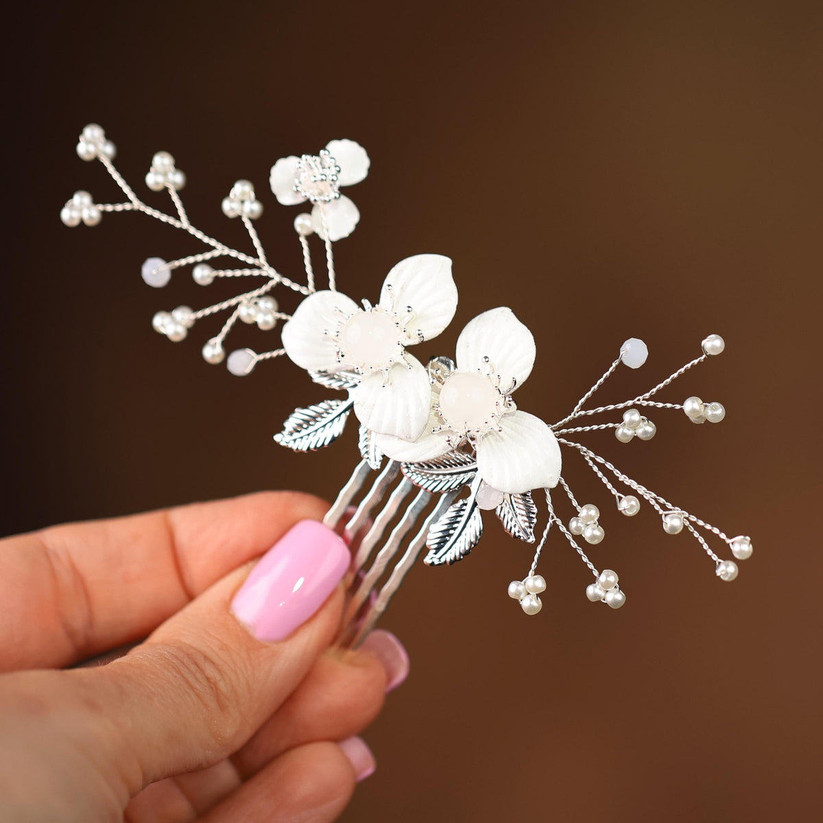 a hand holding a hair comb with flowers on it