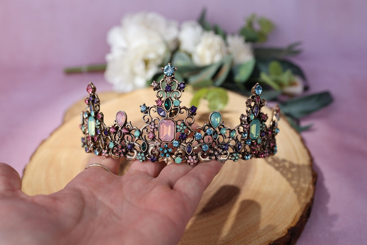 a hand is holding a tiara on a table