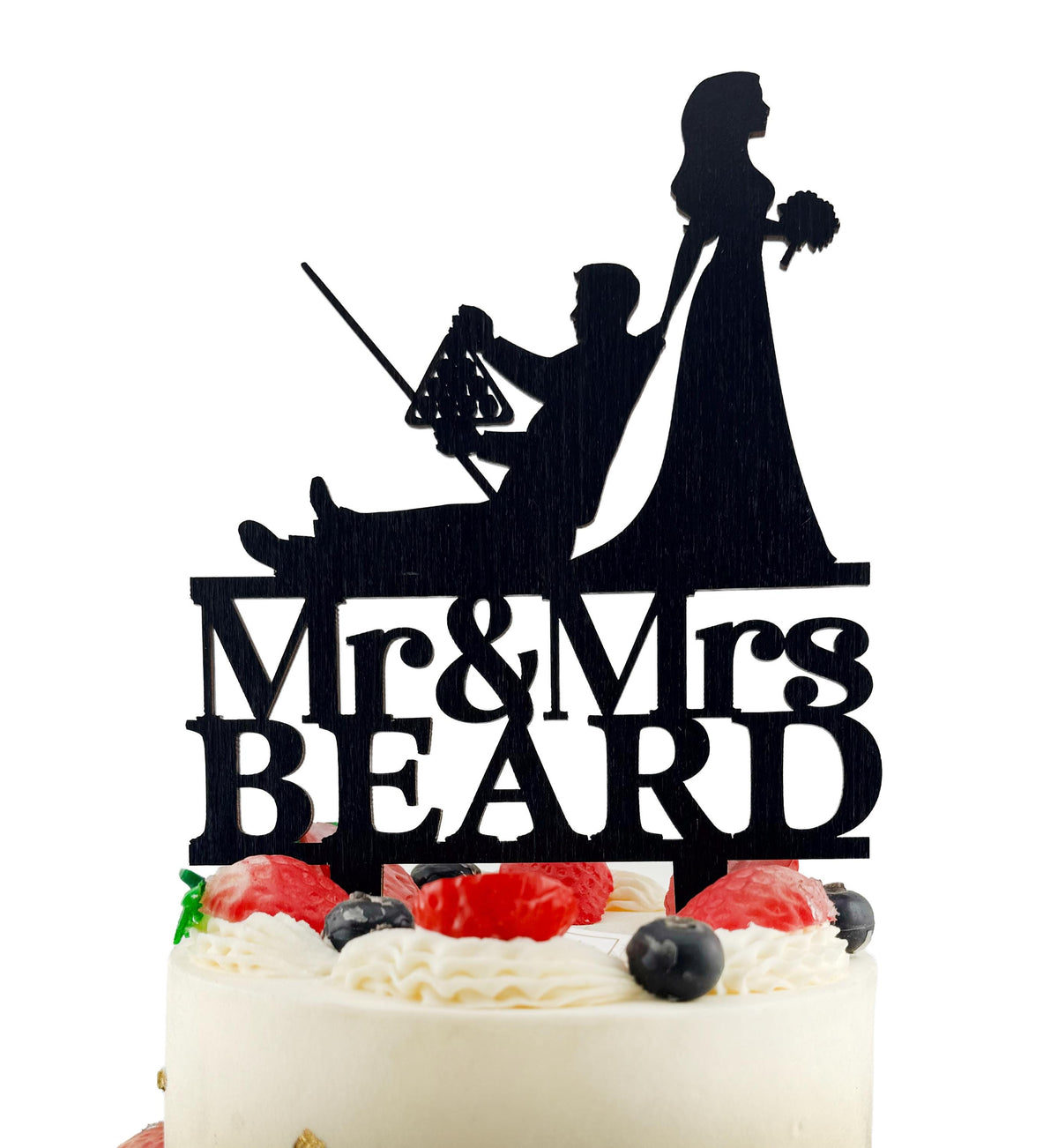 A silhouette of a bride and groom on a cake topper, with the text "Mr & Mrs BEARD" below.