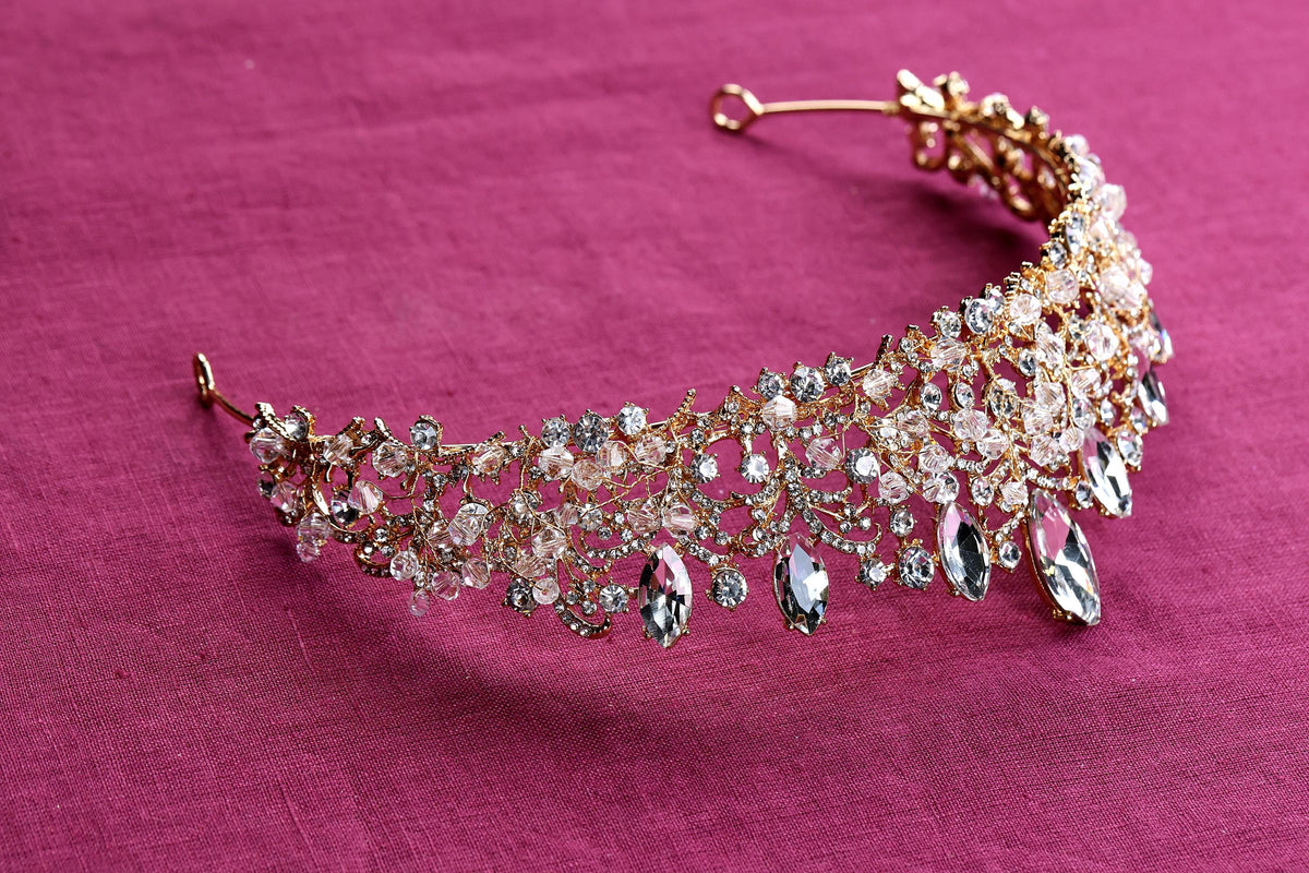 a close up of a tiara on a pink surface