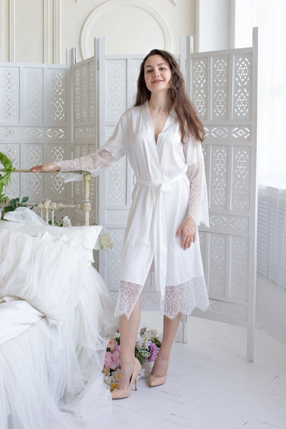 a woman standing next to a bed in a white room