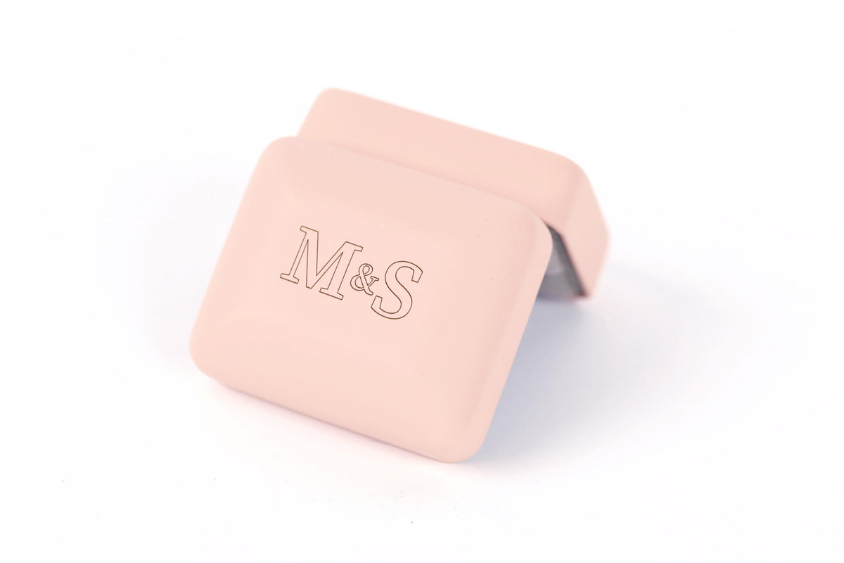 A pink square box with the letters "M&S" printed on it.