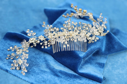 A decorative hair accessory with a floral and crystal design rests on a blue velvet background.