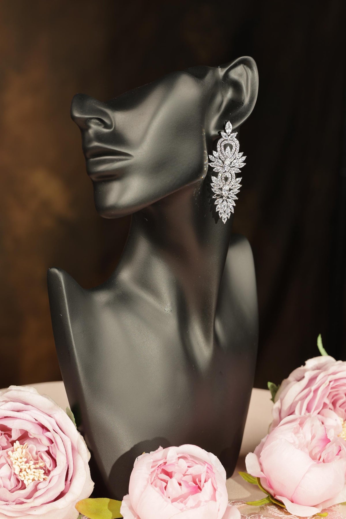 A black mannequin head with a large, ornate necklace featuring a floral design.